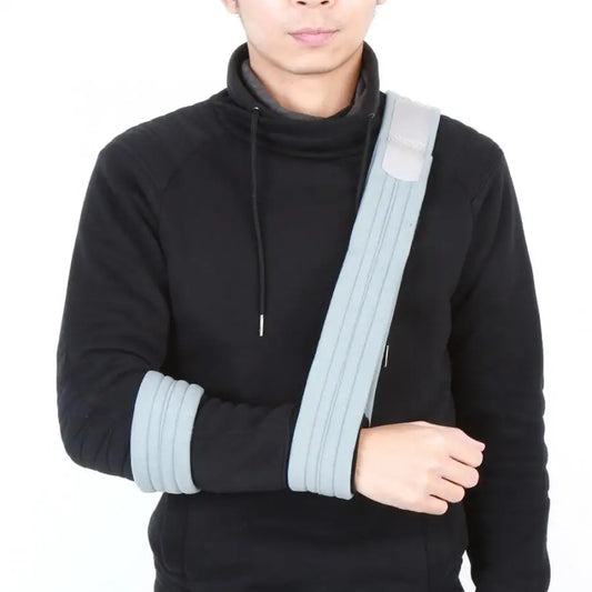 Person wearing shoulder support arm sling for injury recovery